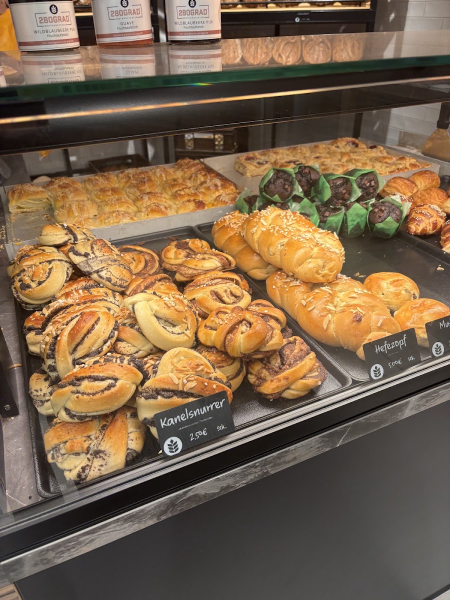 Vitrine mit Kanelsnurrer, Hefezopf und eigenen Fruchtaufstrichen